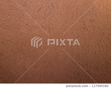 A horizontal background image of a reddish-brown clay wall with a surface that has the texture of straw remaining 117494380