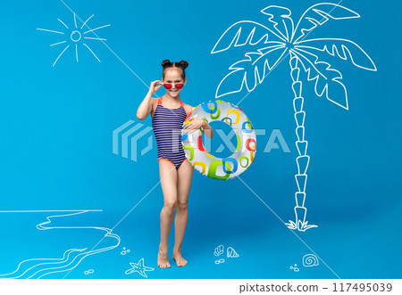 A young girl in a striped swimsuit poses against a blue beach-themed backdrop. She is holding a colorful pool float and wearing red sunglasses. 117495039
