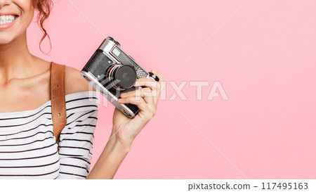 Happy woman with passport and retro camera on pink background, crop 117495163