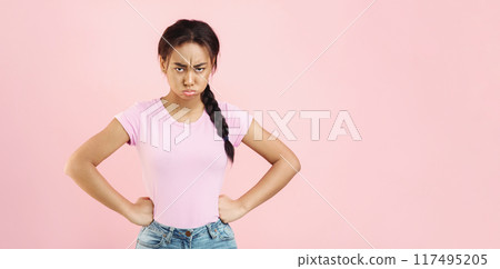 Angry and offended woman, holding hands on hips, looking at camera over pink background, crop Angry and offended woman, holding hands on hips, looking at camera over pink background, crop 117495205