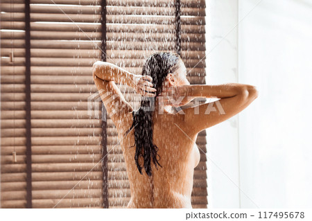 Enjoying shower. Young shirtless woman taking shower, free space Enjoying shower. Young shirtless woman taking shower, free space 117495678