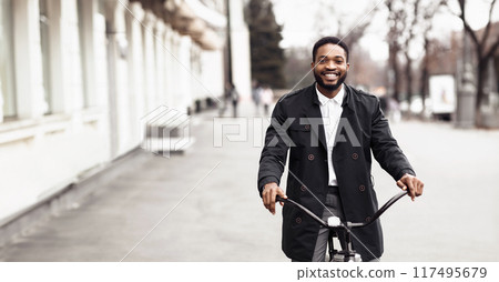 An executive black guy is biking to work in the city center. The setting is contemporary and busy, capturing the blend of professional life and active commuting. An executive black guy is biking to work in the city center. The setting is contemporary and busy, capturing the blend of professional life and active commuting. 117495679