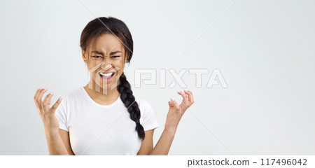 Negative human emotions. Annoyed angry woman holding hands in furious gesture, grey background 117496042