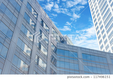 Skyscraper glass building of corporate headquarters in the downtown business area. Towering facade and windows embodying sleek, modern office environment. Financial institution. Modern architecture. 117496151