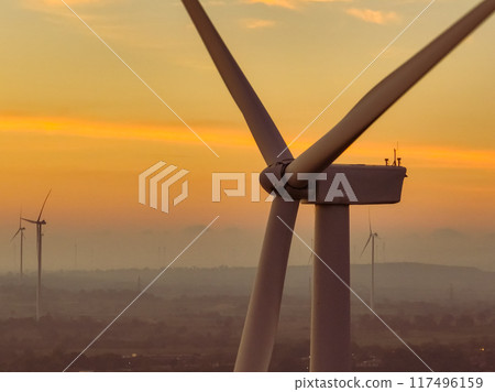 Wind farm field and sunset sky. Wind power. Sustainable, renewable energy. Wind turbines generate electricity. Sustainable development. Green technology for energy sustainability. Eco-friendly energy. 117496159