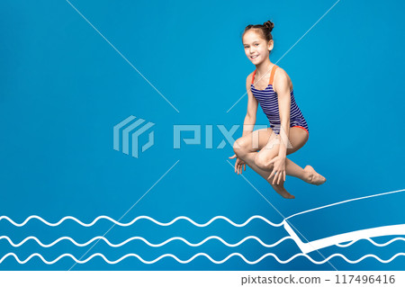 A young girl, wearing a blue and white striped swimsuit, is captured mid-air as she jumps over an illustrated pool. The background is a vibrant blue, copy space 117496416