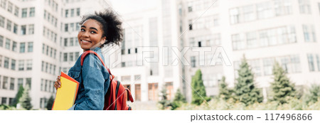 Happy African American Student Girl Posing With Backpack Holding Books Smiling Looking Aside Standing Near University Building Outdoor. Modern Education And Studentship Lifestyle, Copy Space Happy African American Student Girl Posing With Backpack Holding Books Smiling Looking Aside Standing Near University Building Outdoor. Modern Education And Studentship Lifestyle, Copy Space 117496866