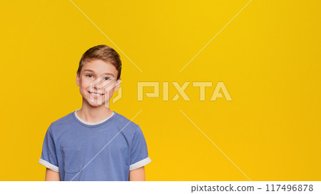 Portrait of young friendly boy on orange studio background 117496878