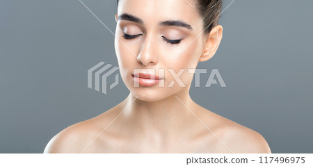 A woman is shown with her eyes closed, hair neatly styled in a bun. She appears calm and composed, possibly meditating or deep in thought. 117496975