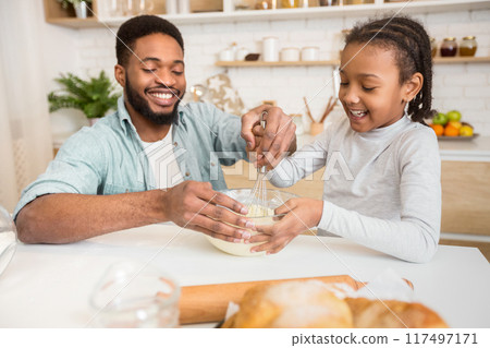 Cheerful African Dad Teaching His Lovely Daughter How To Mix Dough At Home Kitchen Cheerful African Dad Teaching His Lovely Daughter How To Mix Dough At Home Kitchen 117497171