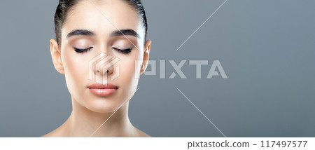 A woman standing with her eyes closed, displaying a moment of introspection or relaxation. She appears deep in thought, possibly meditating or reflecting on something. 117497577