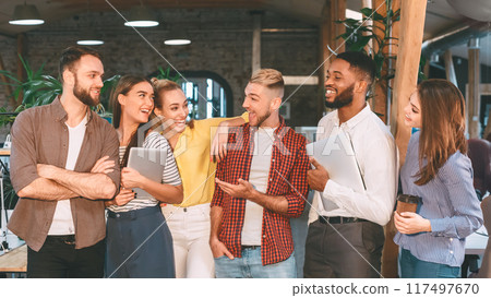 Successful workers having break, talking and laughing in office, holding devices Successful workers having break, talking and laughing in office, holding devices 117497670