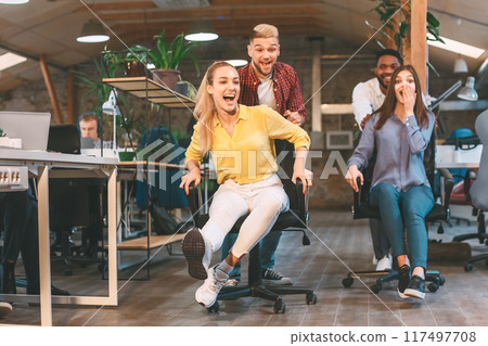 Several individuals are seated around a desk, engaged in a meeting or discussion. 117497708