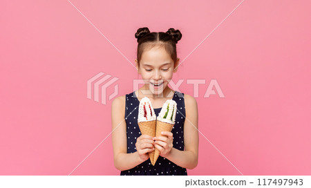 Is it all for me. Happy and surprised girl looking at two ice cream cones with amazement, pink studio background Is it all for me. Happy and surprised girl looking at two ice cream cones with amazement, pink studio background 117497943