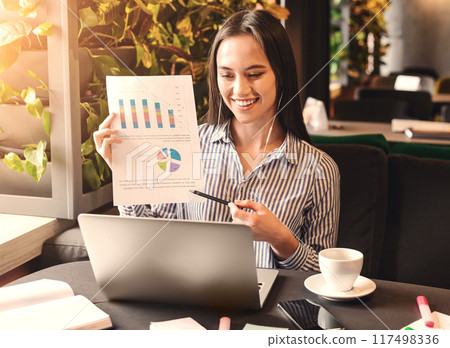 Video conversation. Young millennial woman explaining financial graph to partners via online discussion on laptop, empty space 117498336