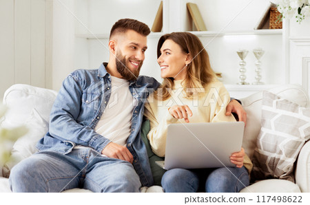 Young Couple Choosing Film On Laptop, Relaxing On Weekend At Home 117498622
