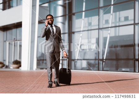 Calling Taxi. Businessman Arriving At Airport, Walking Outdoors And Talking Phone Calling Taxi. Businessman Arriving At Airport, Walking Outdoors And Talking Phone 117498631