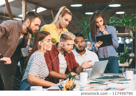 Startup concept. Young colleagues working on new project in modern office, copy space Startup concept. Young colleagues working on new project in modern office, copy space 117498790