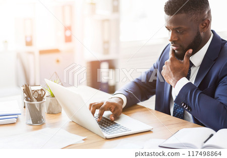 Concentrated young black manager making research online, using laptop, copy space 117498864