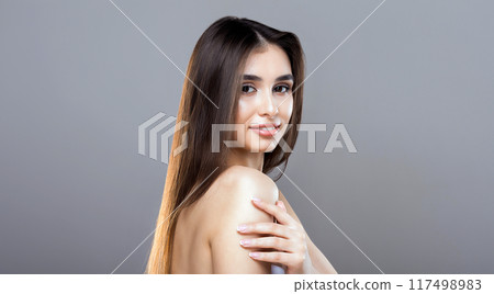 A woman with flowing long hair strikes a pose for a photograph, looking directly at the camera with a confident expression. She stands in a relaxed stance, showcasing her beautiful hair A woman with flowing long hair strikes a pose for a photograph, looking directly at the camera with a confident expression. She stands in a relaxed stance, showcasing her beautiful hair 117498983