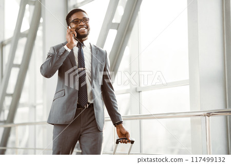 Always in Touch. Busy Man Talking on Phone, Walking in Airport, Free Space 117499132