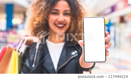 Online shopping concept. Young african woman showing cellphone screen with blank space for advertisement 117499224