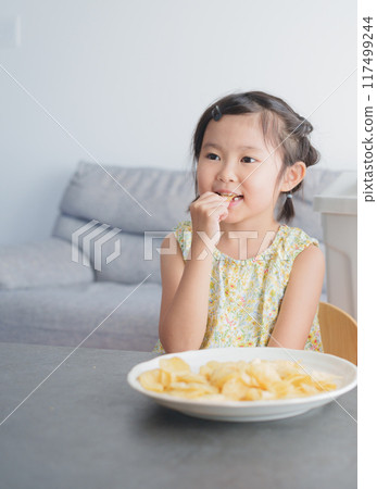 Child eating potato chips snack Child eating potato chips snack 117499244