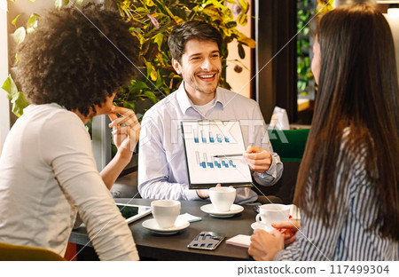 Managers analyzing chart at a business lunch, discussing successful project at cafe, free space Managers analyzing chart at a business lunch, discussing successful project at cafe, free space 117499304