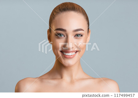 Beauty portrait. Beautiful woman with perfect smile and clean skin over grey studio background Beauty portrait. Beautiful woman with perfect smile and clean skin over grey studio background 117499457