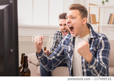 Intense excitement as two european guys cheer on their team, embodying the passion of friendship and sports enthusiasm Intense excitement as two european guys cheer on their team, embodying the passion of friendship and sports enthusiasm 117499516