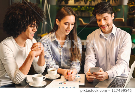 Young creative team on meeting discussing project with smartphone in cafe, business lunch concept Young creative team on meeting discussing project with smartphone in cafe, business lunch concept 117499545