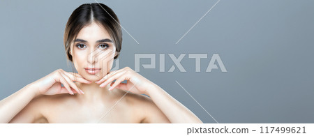 A woman without a shirt stands confidently, posing for a photo. Her arms are strategically placed to cover her chest as she gazes directly at the camera, blank space A woman without a shirt stands confidently, posing for a photo. Her arms are strategically placed to cover her chest as she gazes directly at the camera, blank space 117499621