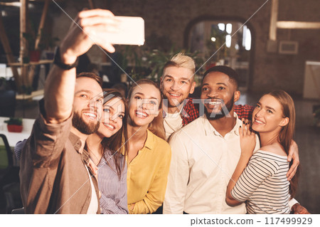 Happy international creative business team taking selfie at office 117499929