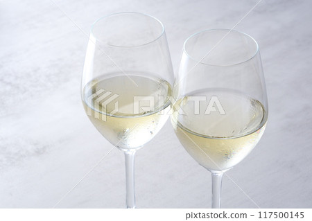 Image of a toast with two wine glasses filled with white wine 117500145