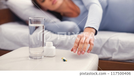 Pregnancy. Unrecognizable Pregnant Woman Taking Medicine Pill Lying In Bed In Bedroom. Cropped, Panorama, Selective Focus Pregnancy. Unrecognizable Pregnant Woman Taking Medicine Pill Lying In Bed In Bedroom. Cropped, Panorama, Selective Focus 117500406