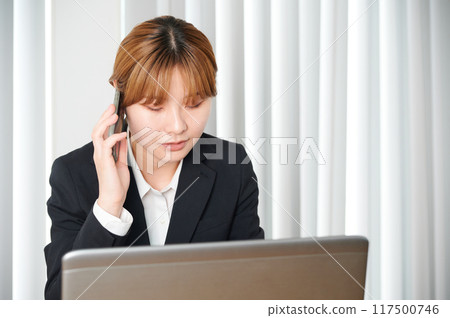 Woman talking on smartphone, suit, working from home Woman talking on smartphone, suit, working from home 117500746