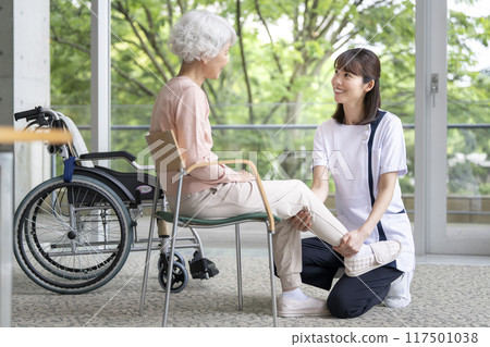 Senior woman undergoing rehabilitation and staff in white coats 117501038