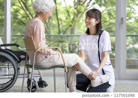 Physiotherapist rehabilitating a senior woman 117501098