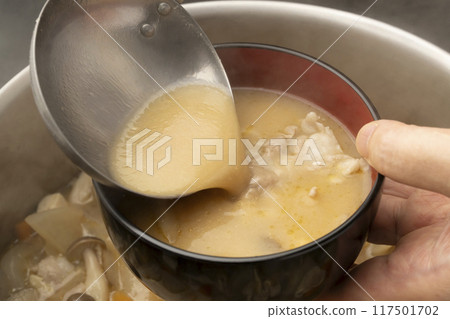 豬肉湯：用湯匙將豬肉湯倒入碗中。 117501702