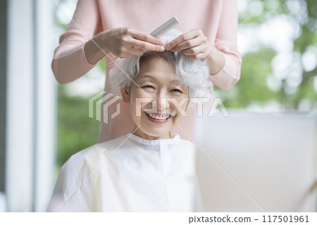 高級婦女正在由美髮師理髮 高級婦女正在由美髮師理髮 117501961