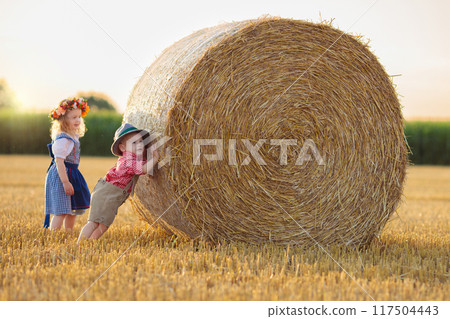 Child in wheat field with German bread 117504443