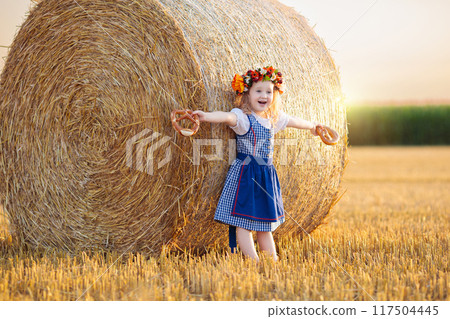Child in wheat field with German bread Child in wheat field with German bread 117504445