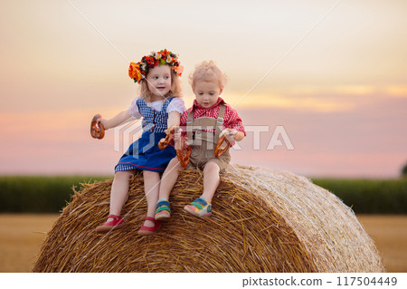 Child in wheat field with German bread 117504449