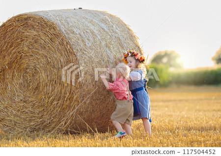 Child in wheat field with German bread 117504452