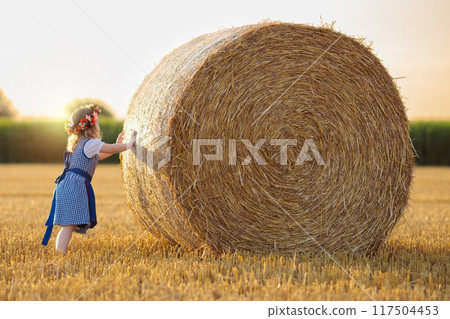 Child in wheat field with German bread Child in wheat field with German bread 117504453