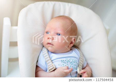 Newborn baby boy in high chair 117504458