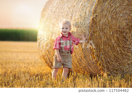Child in wheat field with German bread 117504462