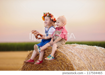 Child in wheat field with German bread 117504465