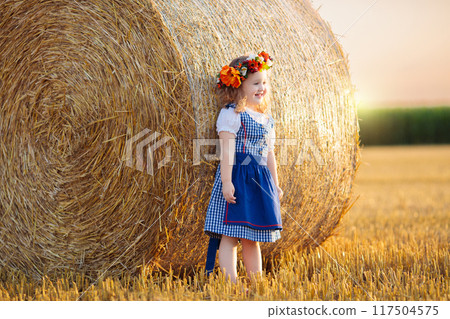 Child in wheat field with German bread 117504575