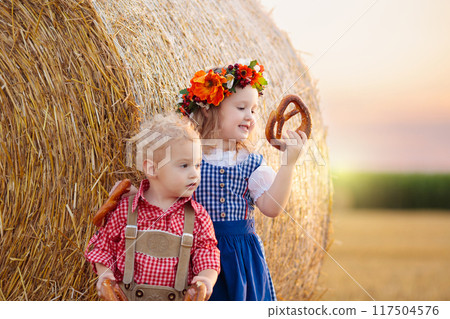 Child in wheat field with German bread Child in wheat field with German bread 117504576